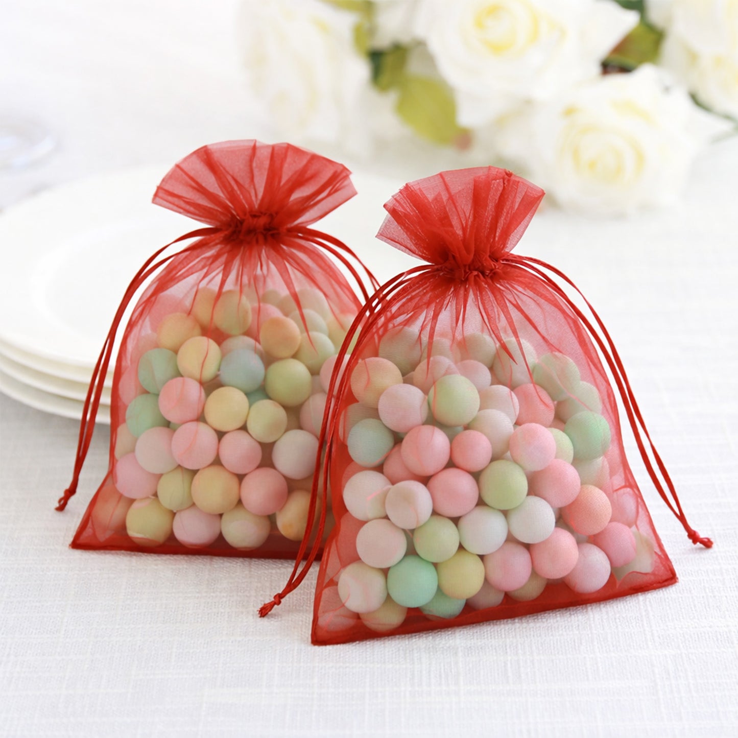Red organza gift bags with drawstring, perfect for wedding favors.