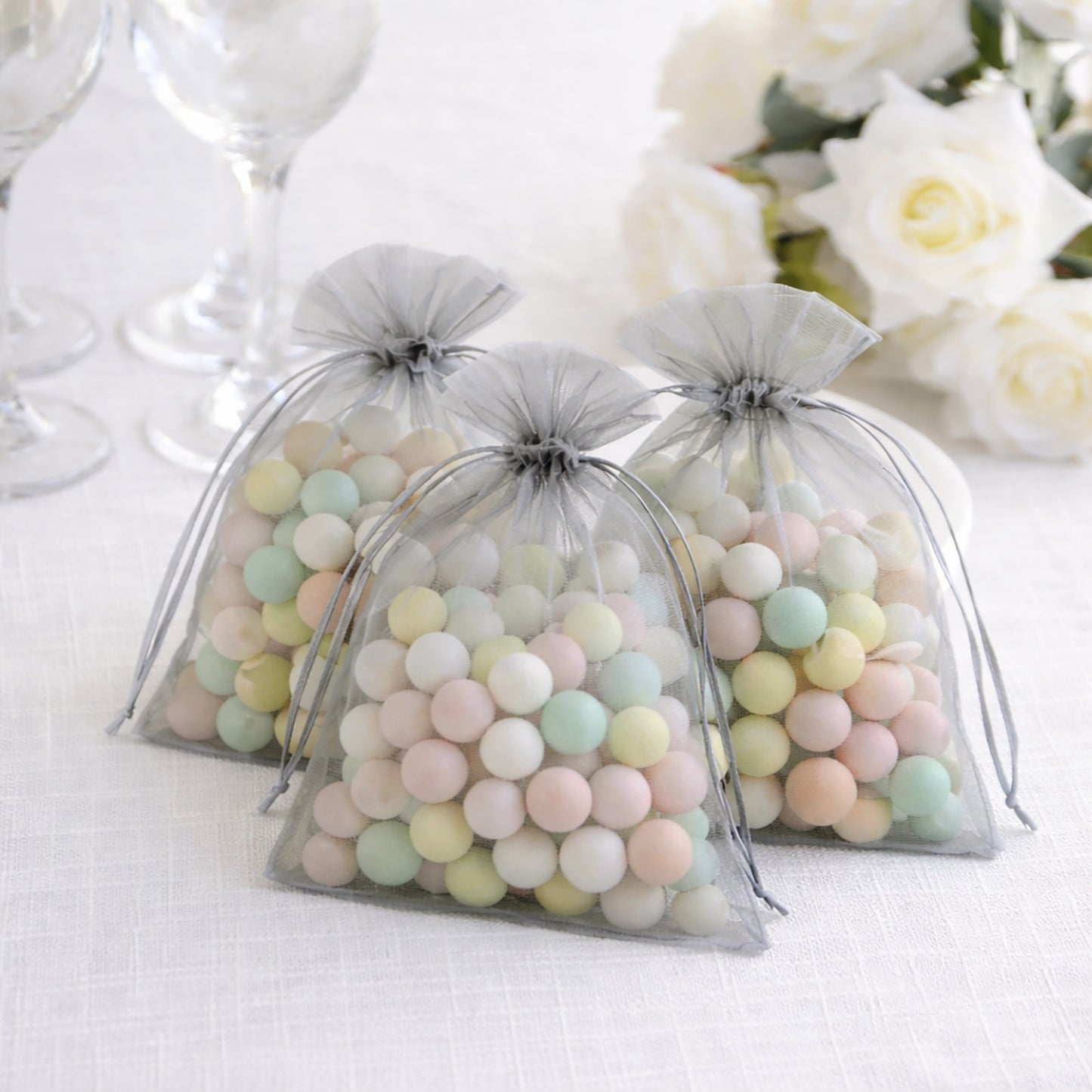Silver organza gift bags filled with pastel candies.
