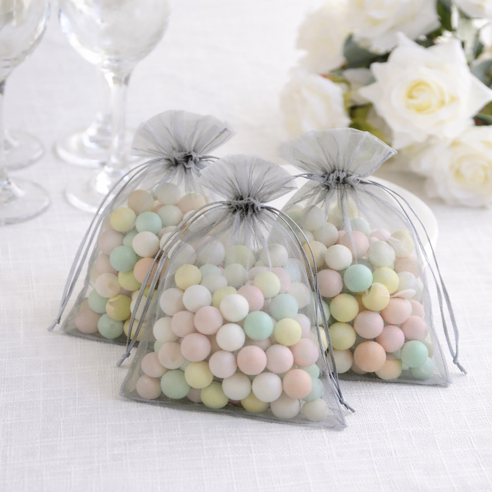 Silver organza gift bags filled with pastel candies.