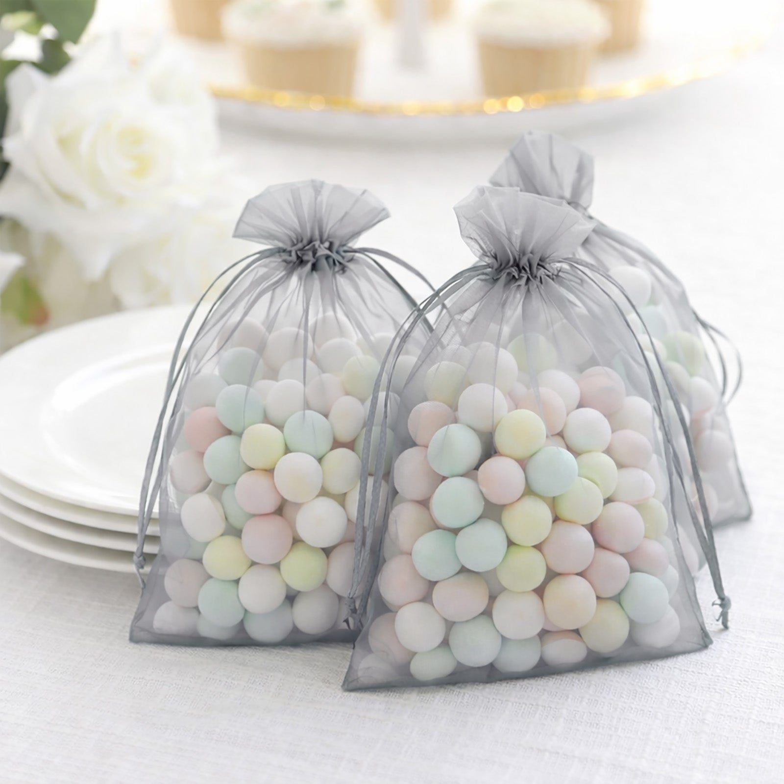 Silver organza gift bags filled with pastel candies.