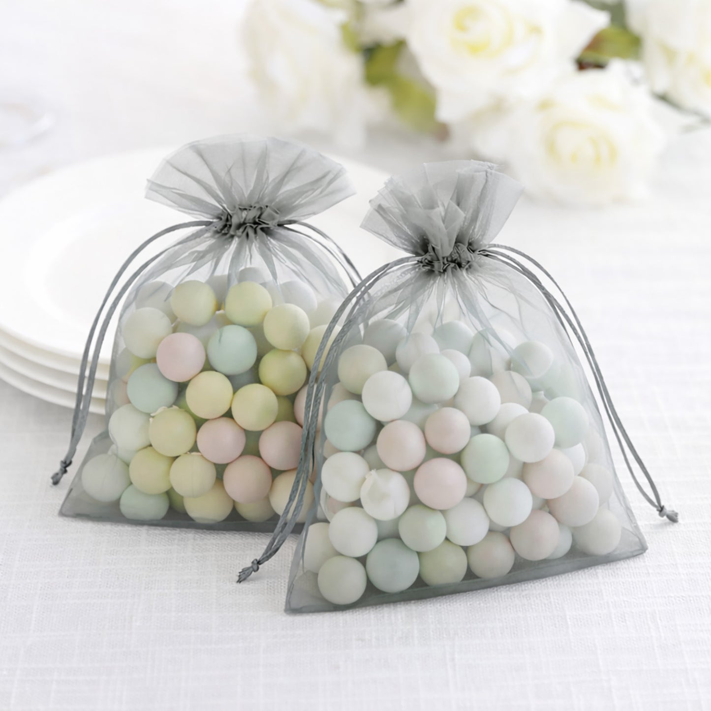 Silver organza gift bags filled with pastel candies.