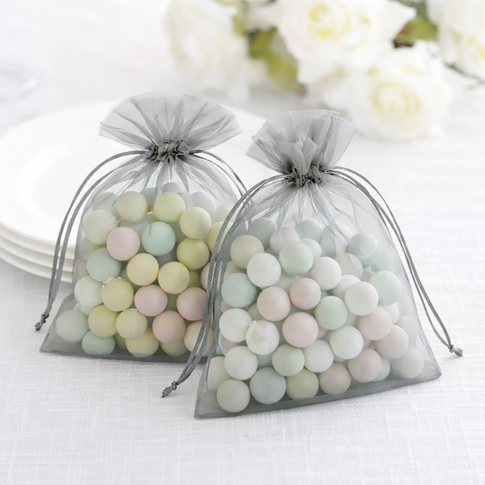 Silver organza gift bags filled with pastel candies.
