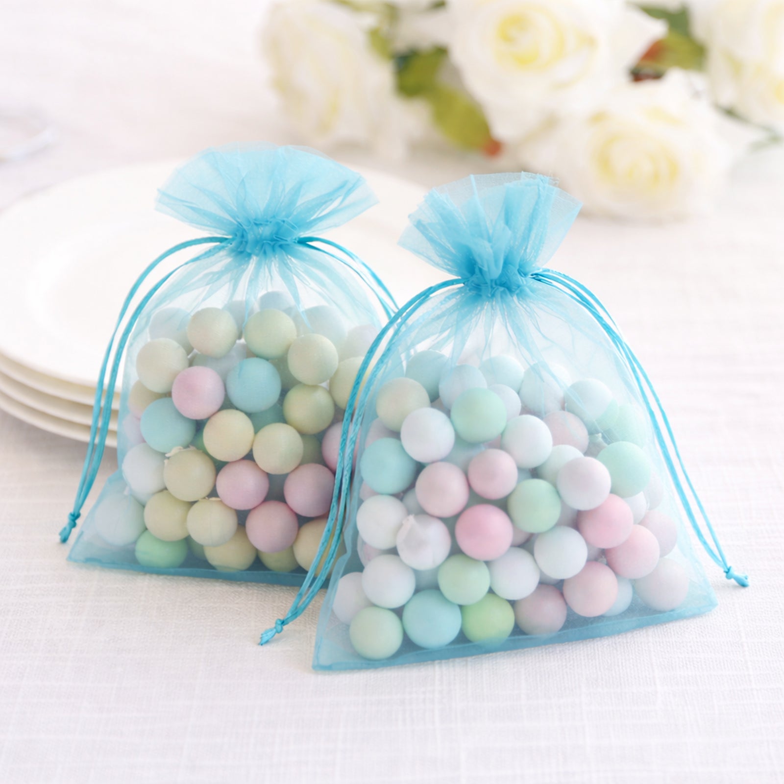Turquoise organza gift bags filled with colorful decorative balls.