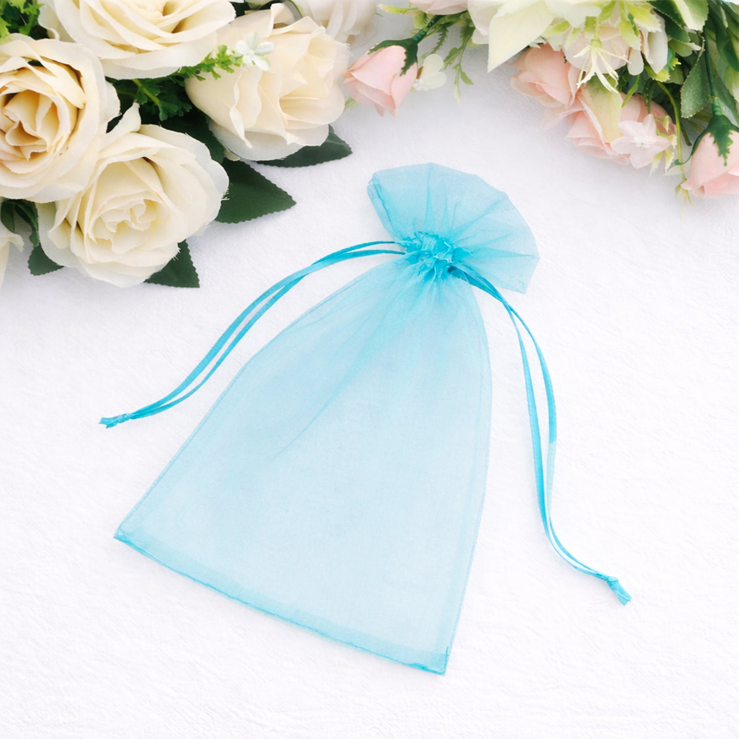 Turquoise organza gift bag with drawstring, perfect for wedding favors.