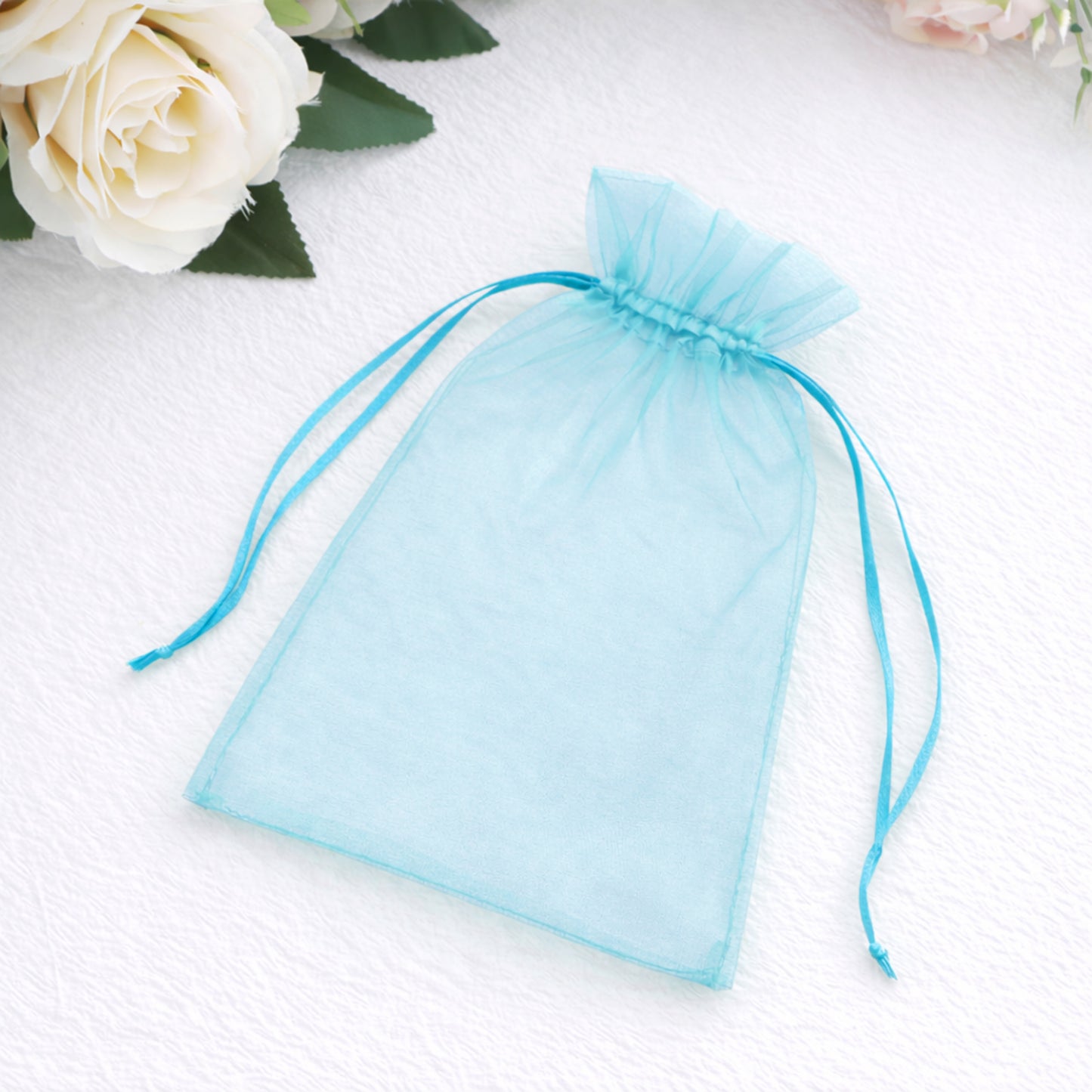 Turquoise organza gift bag with drawstring, 5" x 7" size.