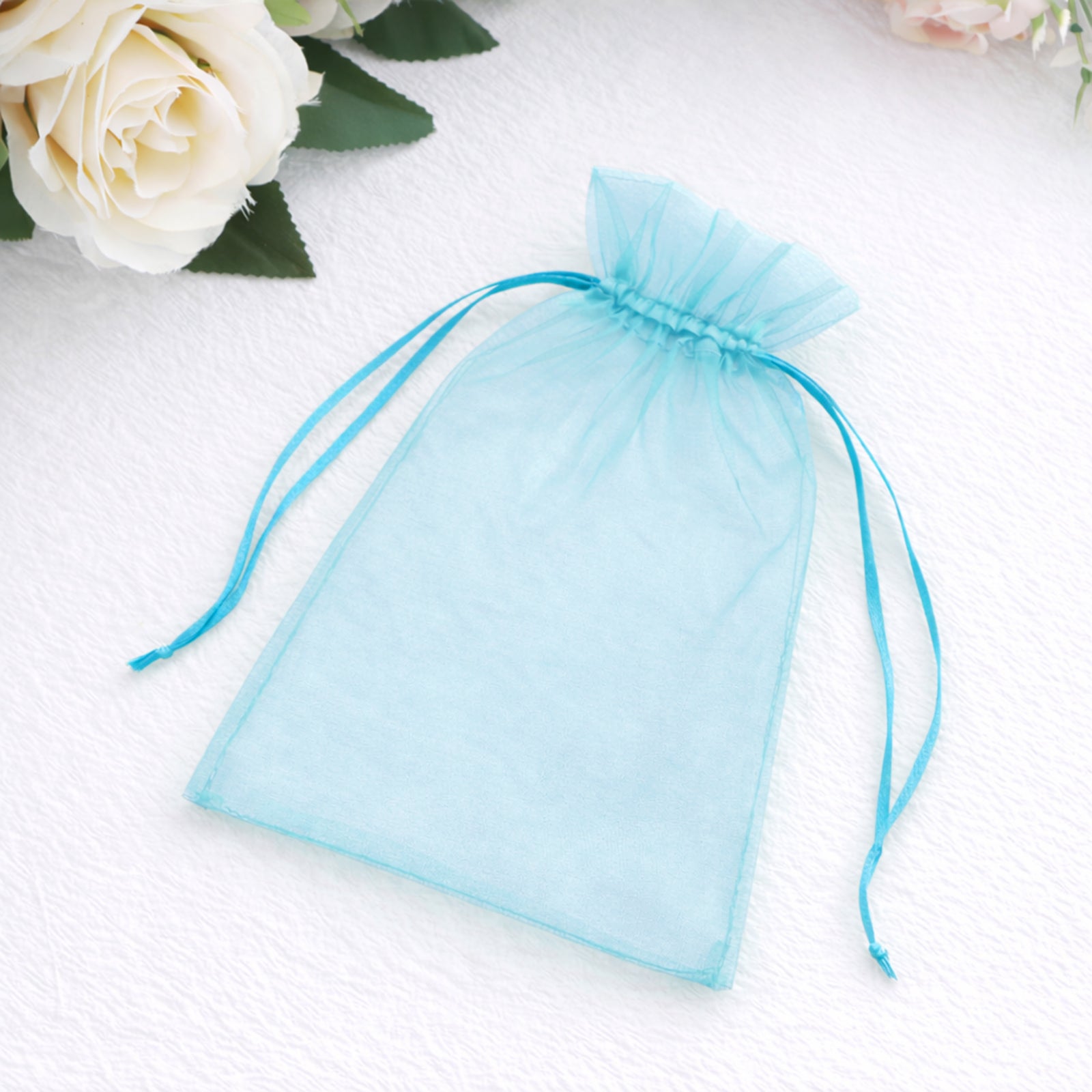 Turquoise organza gift bag with drawstring, 5" x 7" size.
