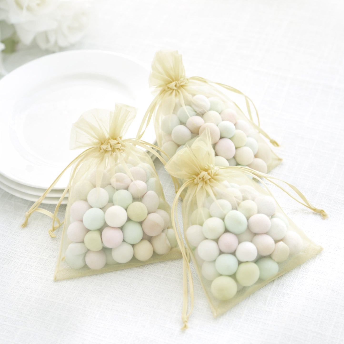 Yellow organza gift bags with drawstring, perfect for wedding favors.