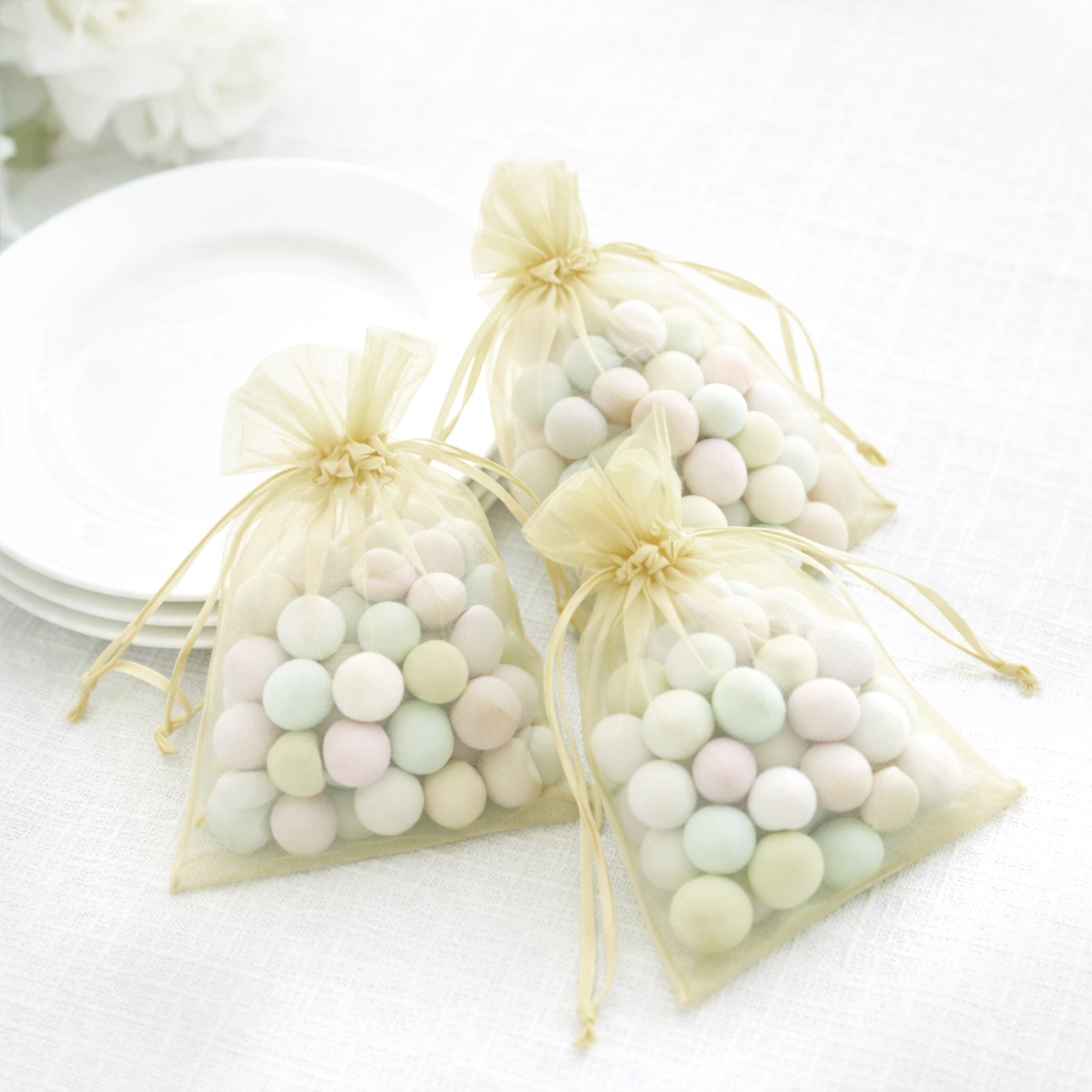 Yellow organza gift bags with drawstring, perfect for wedding favors.