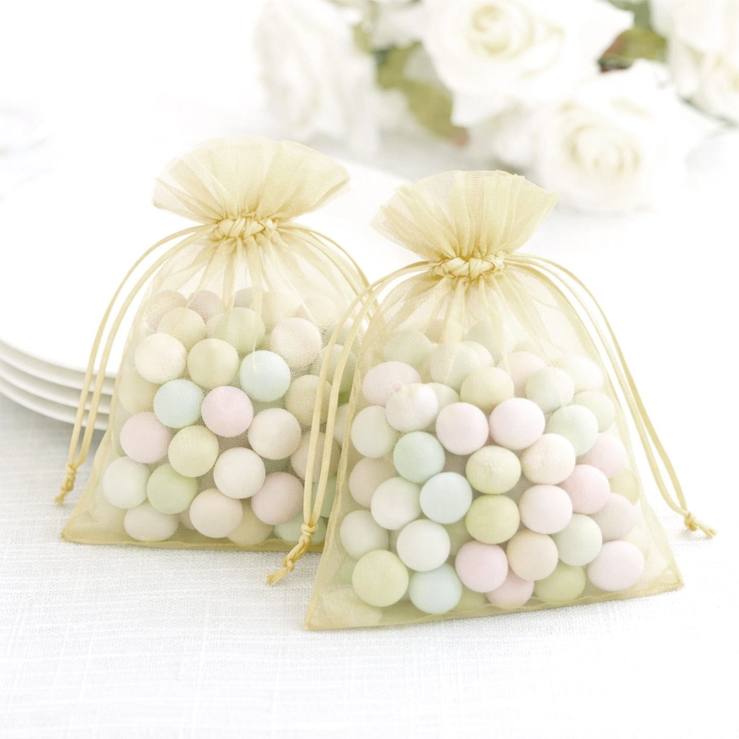 Yellow organza gift bags filled with pastel candies.