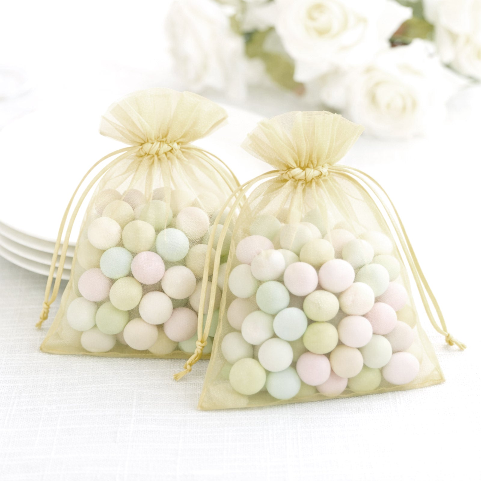 Yellow organza gift bags filled with pastel candies.