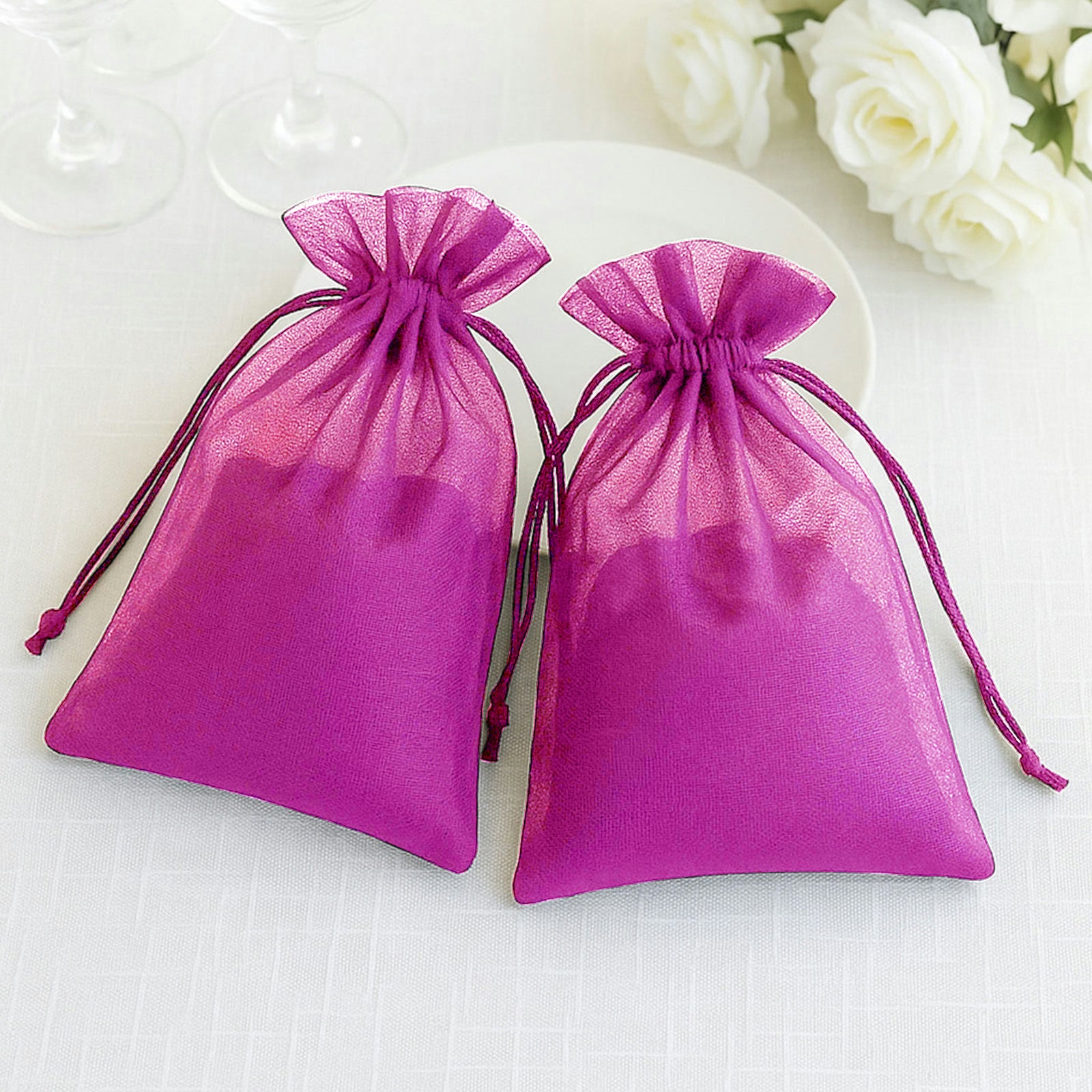Fuchsia organza gift bags with drawstring, perfect for wedding favors.