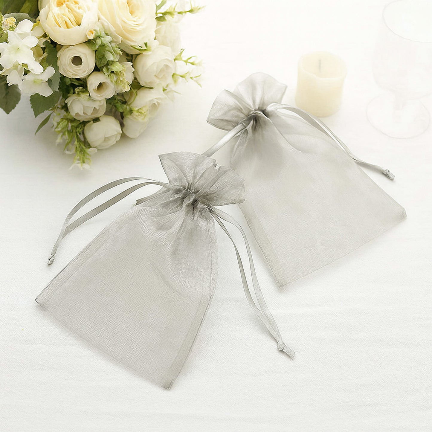 Silver organza gift bags with drawstring, perfect for wedding favors.