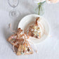 Metallic rose gold drawstring candy bags on a plate.