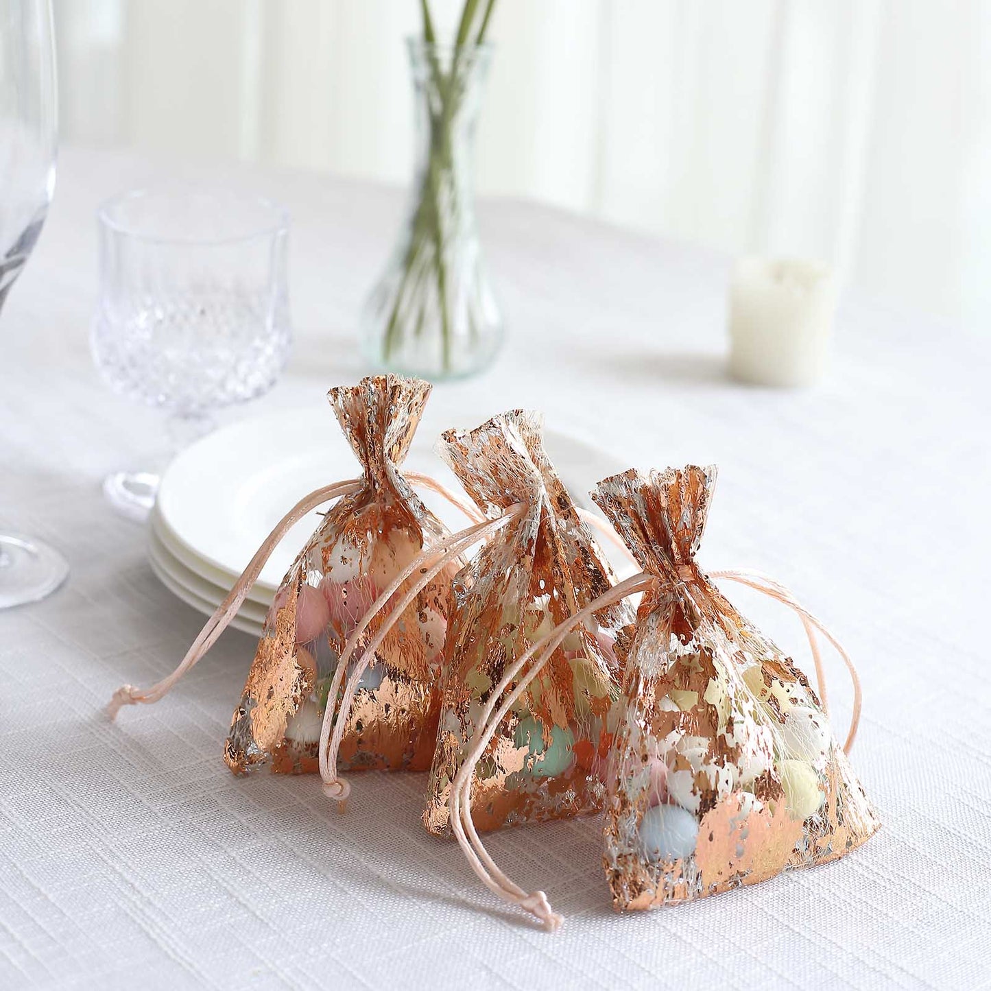 Metallic rose gold foil drawstring candy bags for wedding favors.