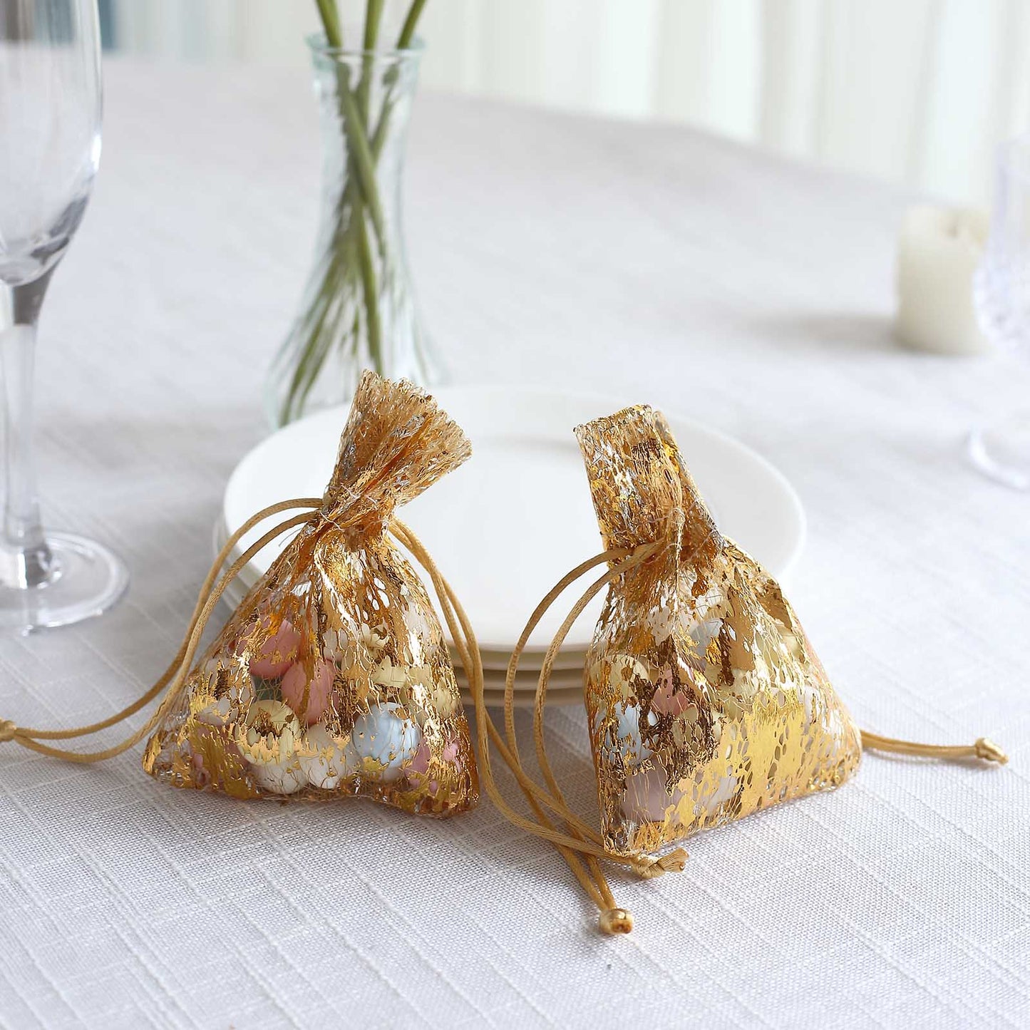 Metallic gold drawstring candy bags, perfect for wedding party favors.