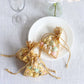 Metallic gold drawstring candy bags on a plate, ideal for wedding favors.