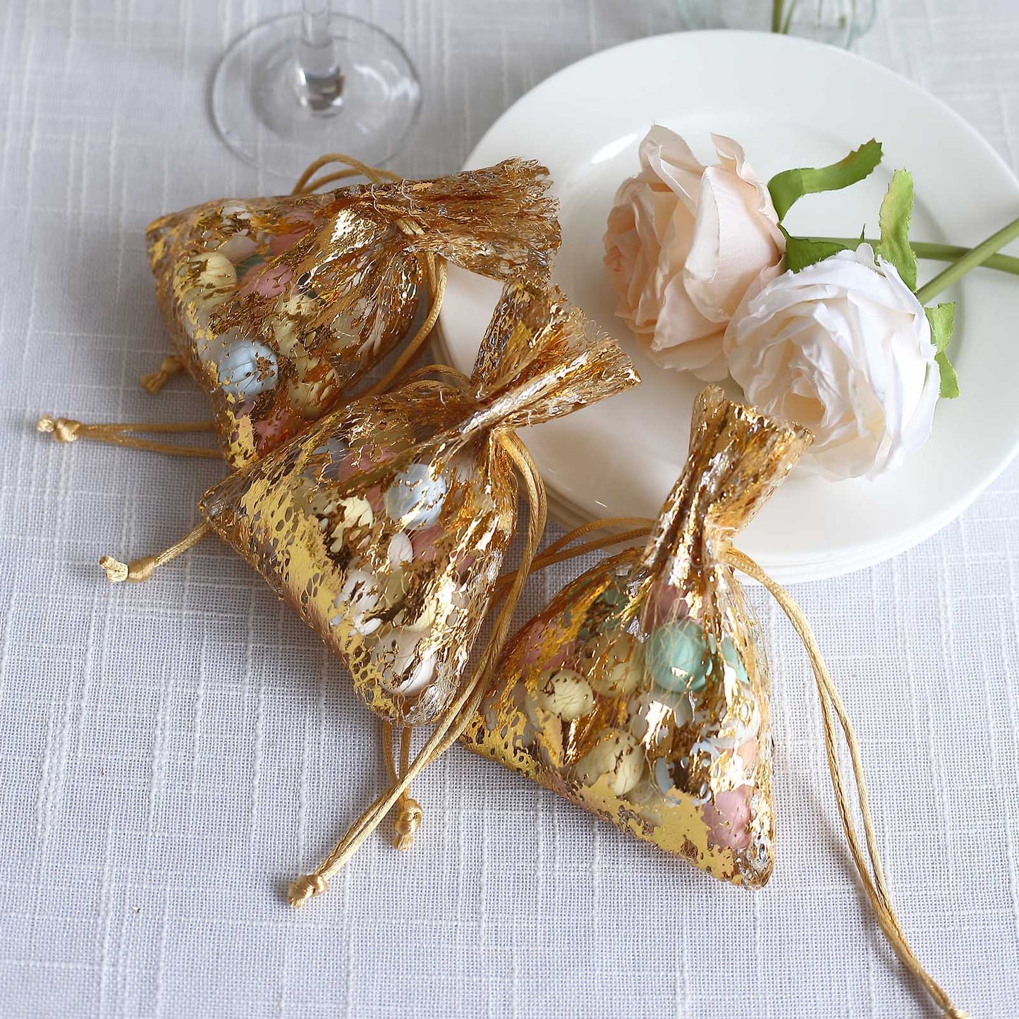 Metallic gold foil drawstring candy bags for wedding party favors.