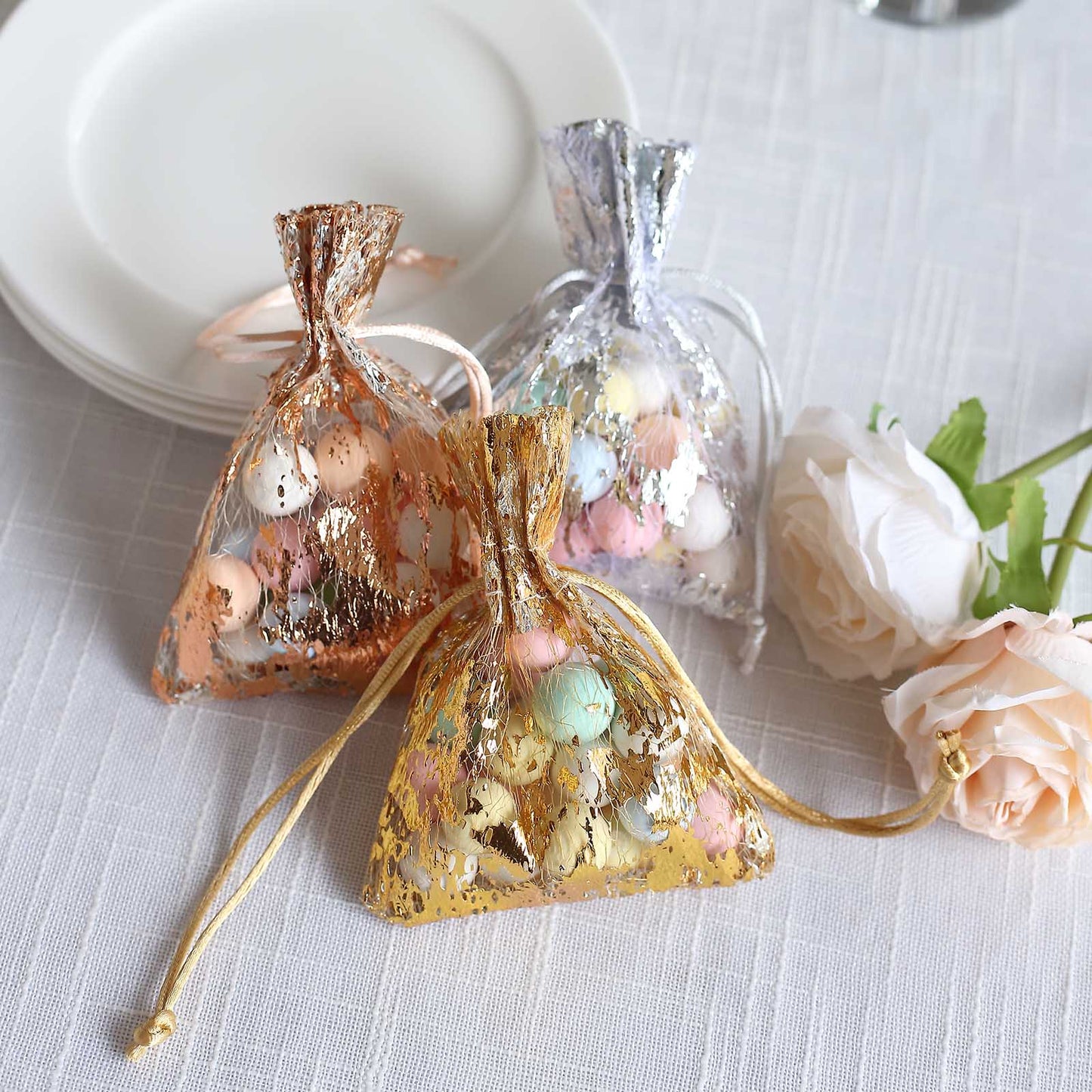 Metallic gold drawstring candy bag with pastel candies inside.