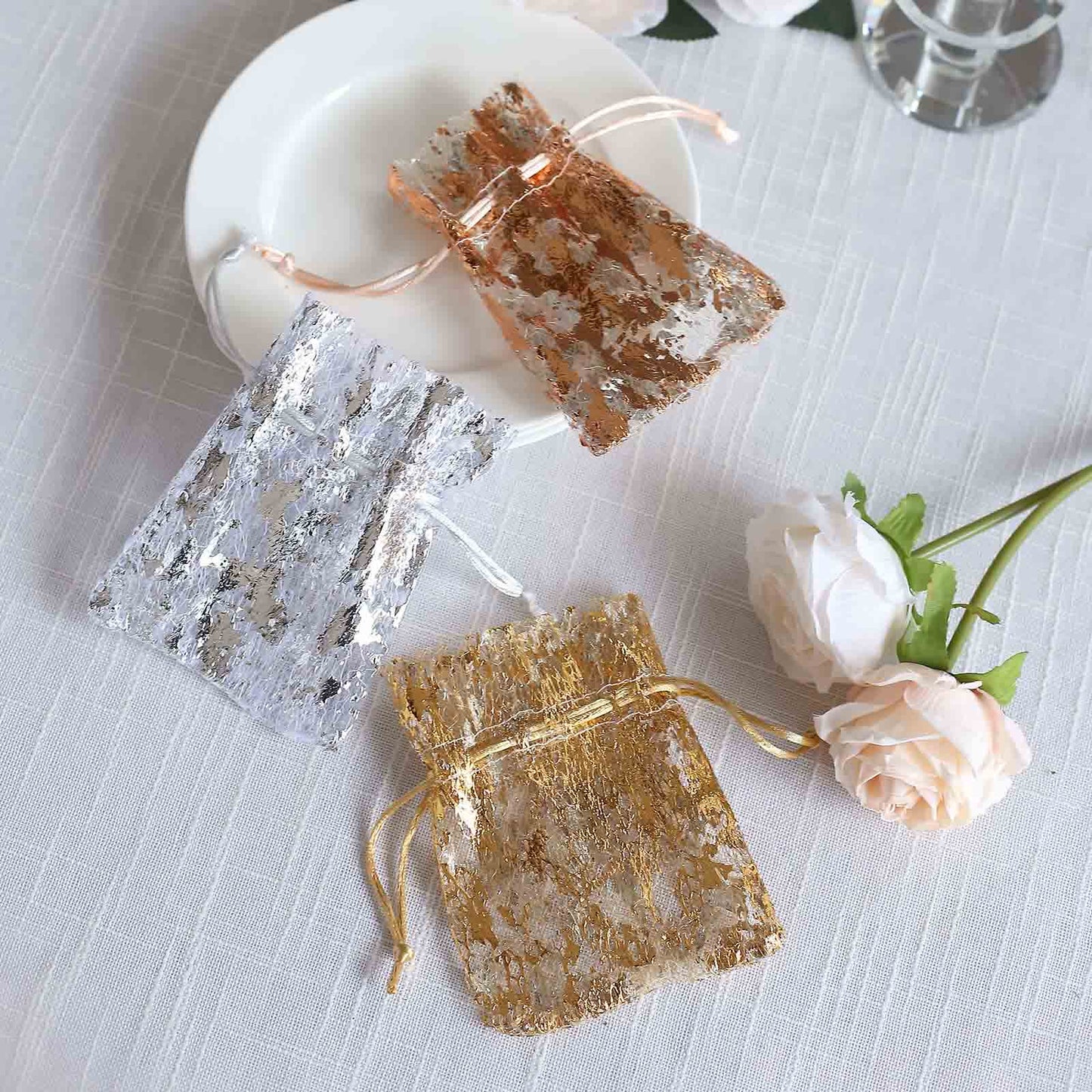 Metallic gold foil drawstring candy bag on a white plate.
