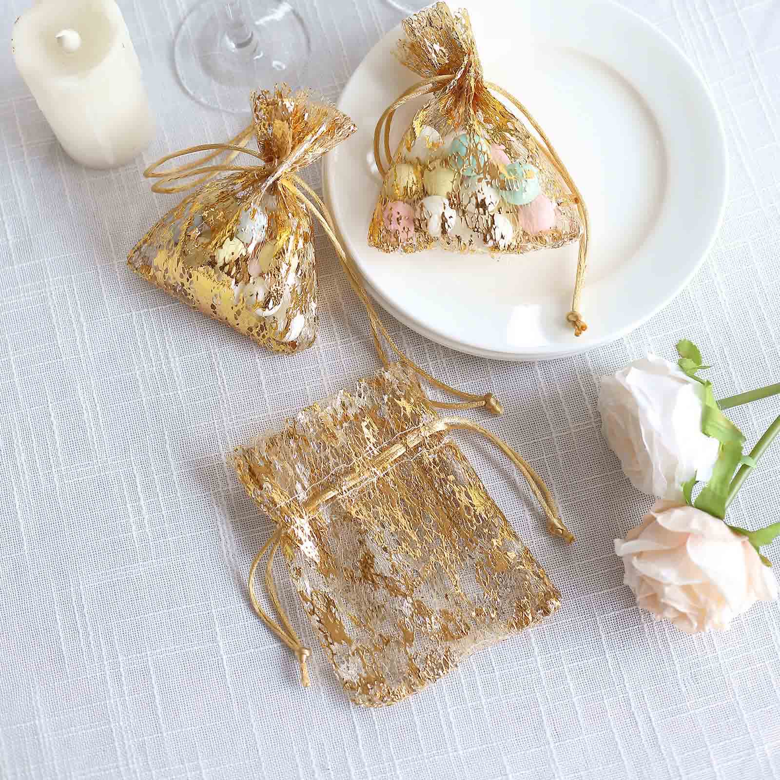 Metallic gold foil drawstring candy bags on a table setting.