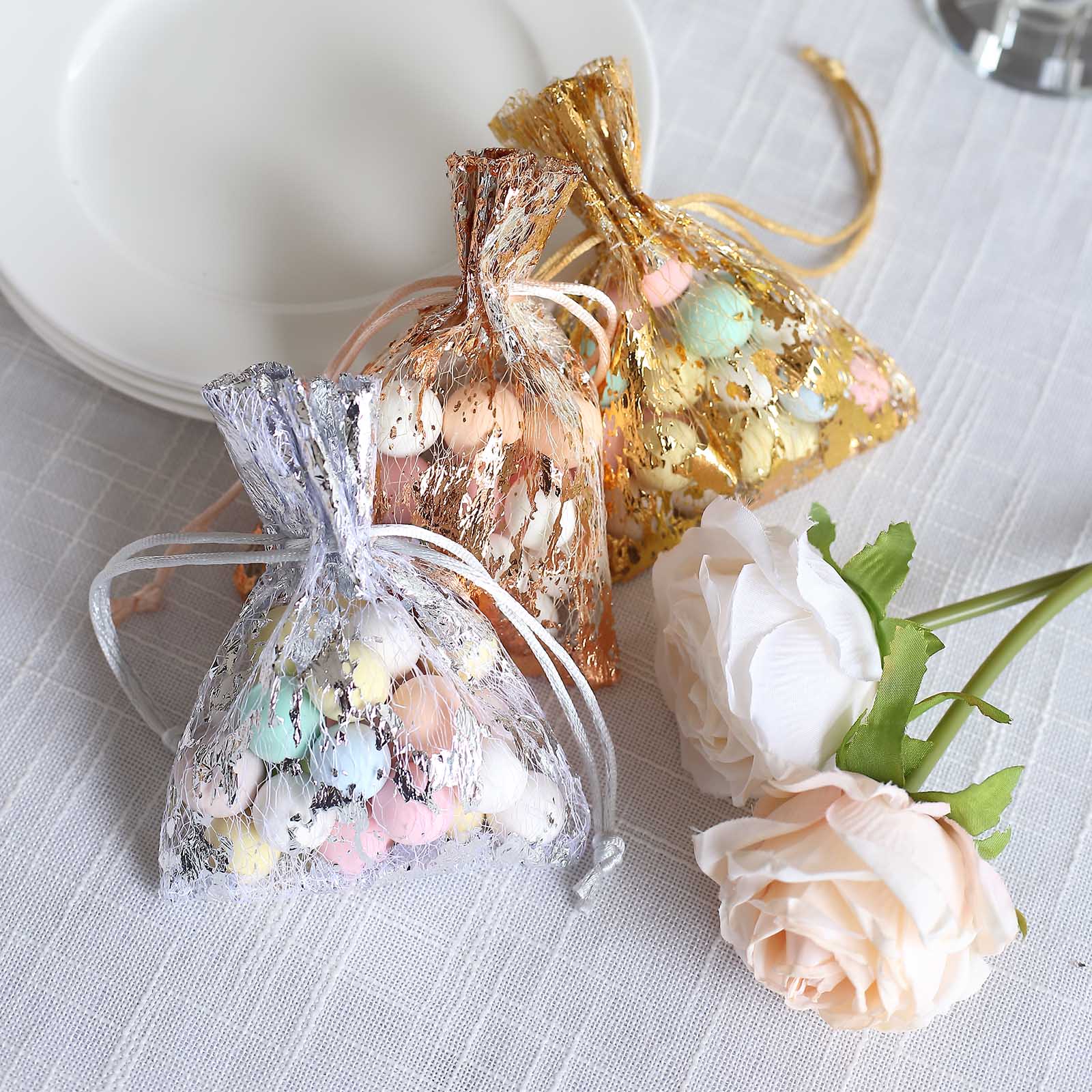 Metallic silver foil drawstring candy bags with pastel candies, wedding party favor.