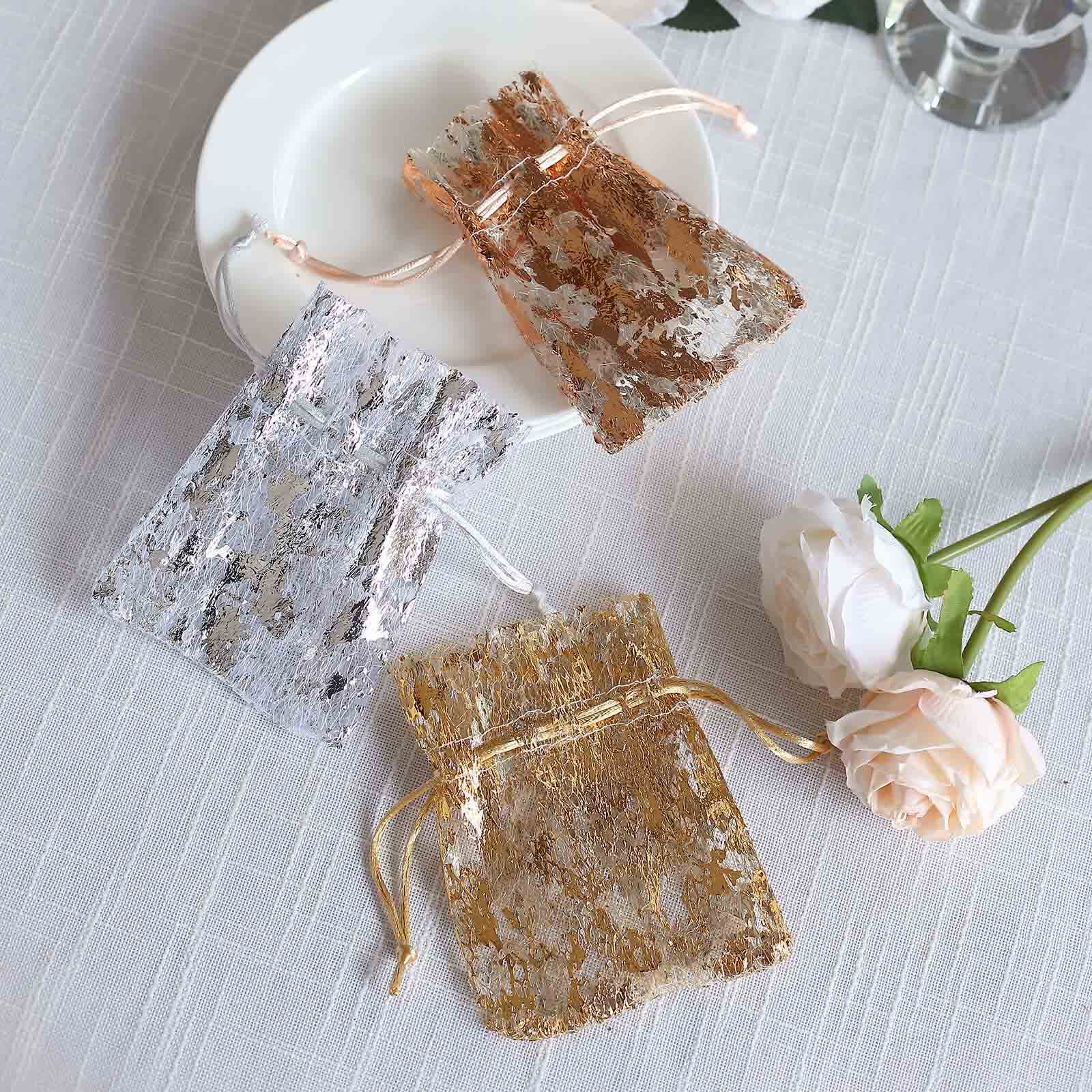 Metallic silver foil drawstring candy bags on a plate, perfect for wedding favors.