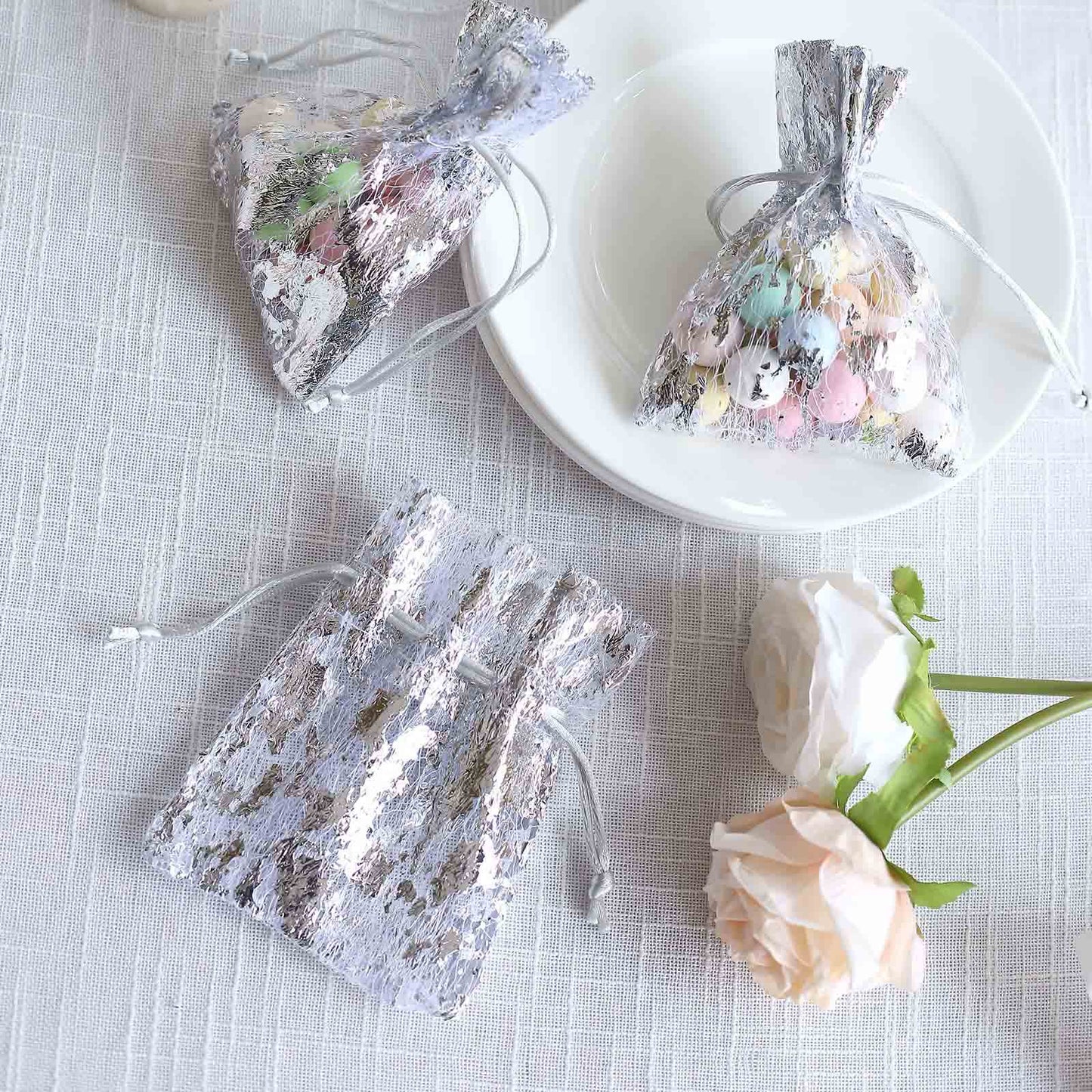 Metallic silver foil drawstring candy bags with pastel candies.