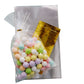 Clear gift bags with gold twist ties filled with colorful candies.