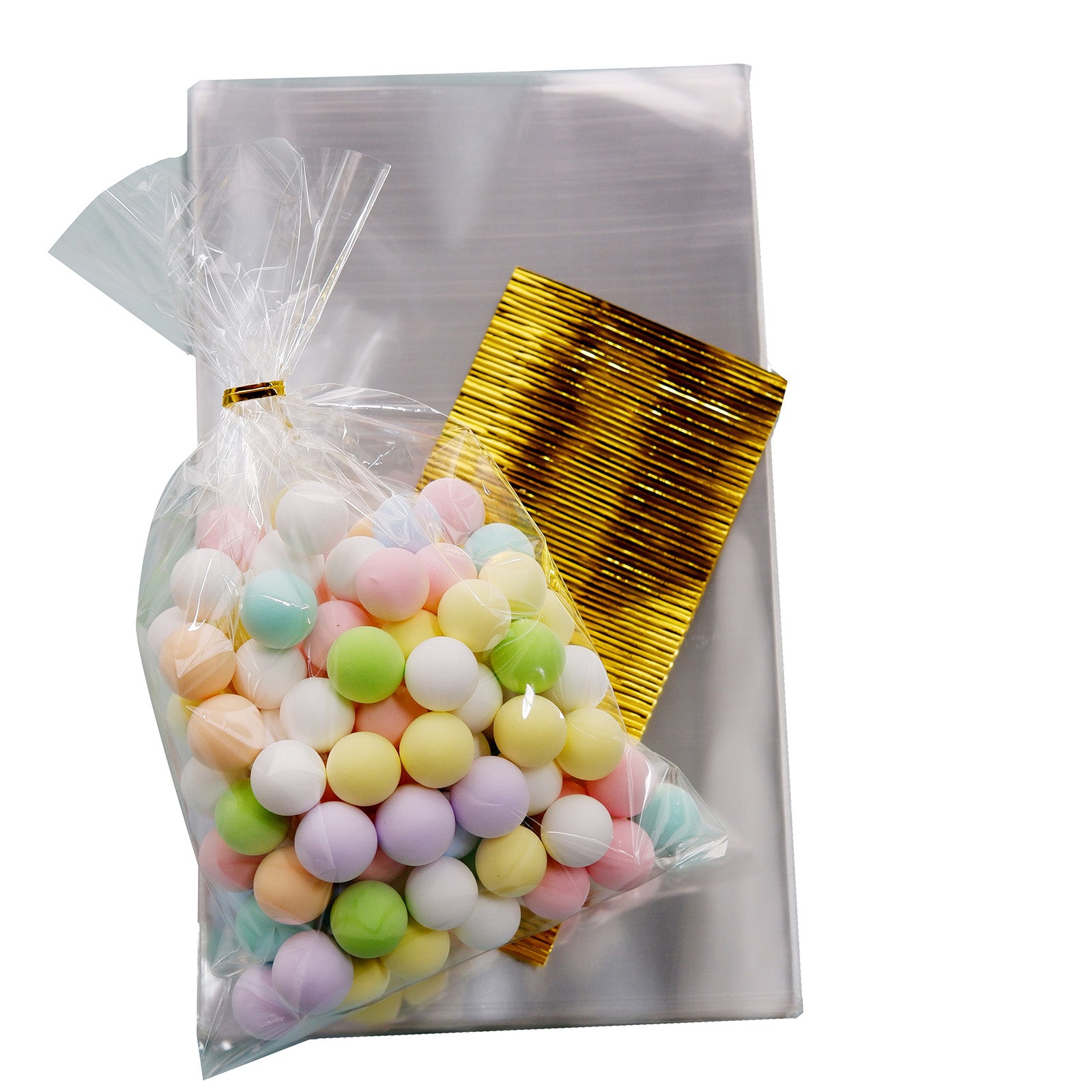 Clear gift bags with gold twist ties filled with colorful candies.