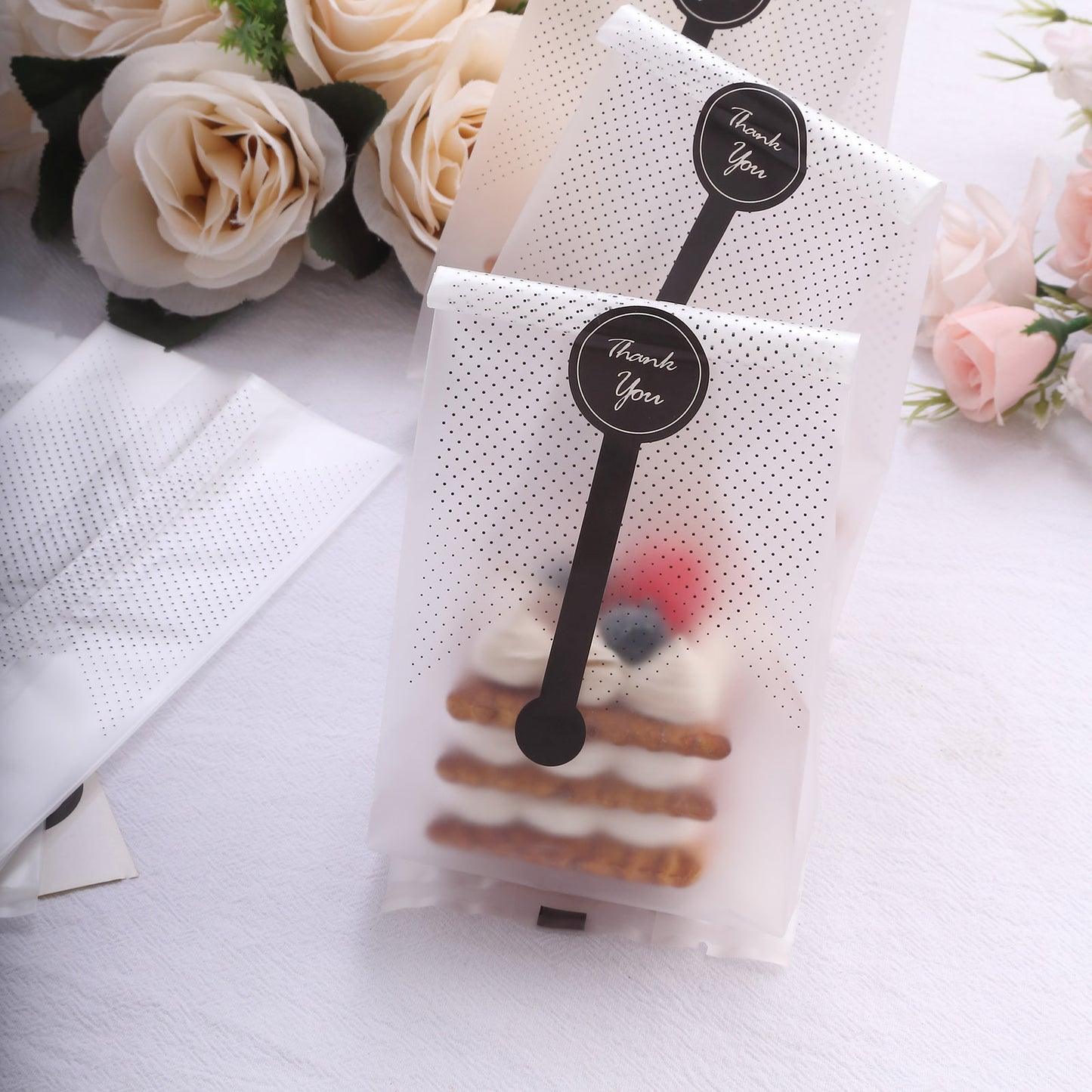 Clear black dotted gift bags with "Thank You" stickers for party favors.