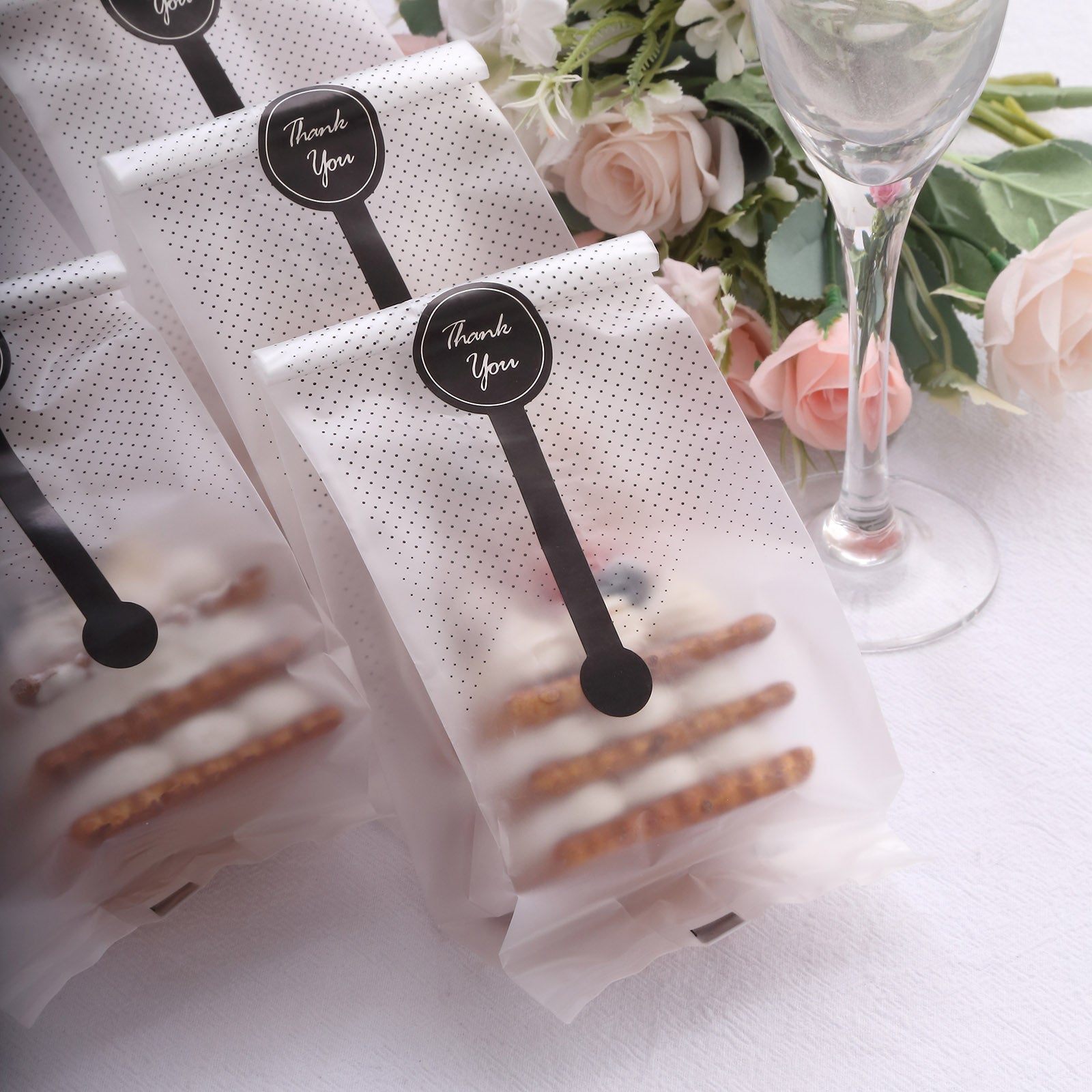 Clear plastic goodie bags with black dots and "Thank You" stickers.
