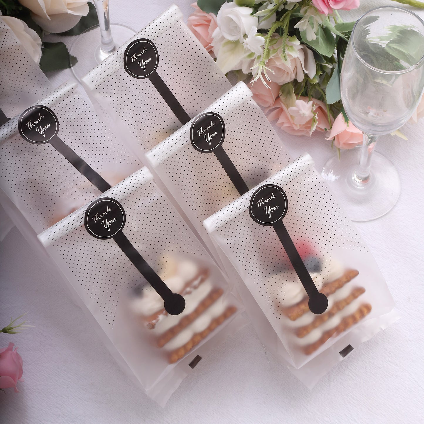 Clear black dotted gift bags with "Thank You" stickers, perfect for party favors.