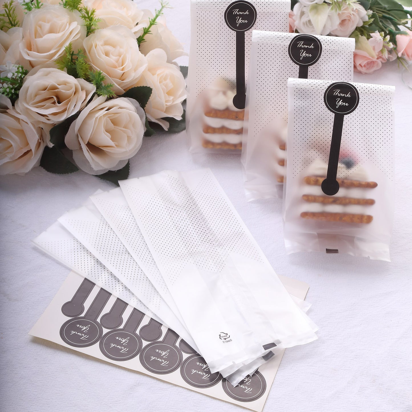 Clear black dotted goodie bags with "Thank You" stickers for party favors.