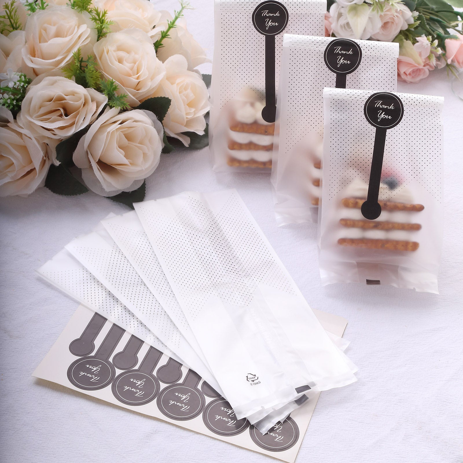 Clear black dotted goodie bags with "Thank You" stickers for party favors.