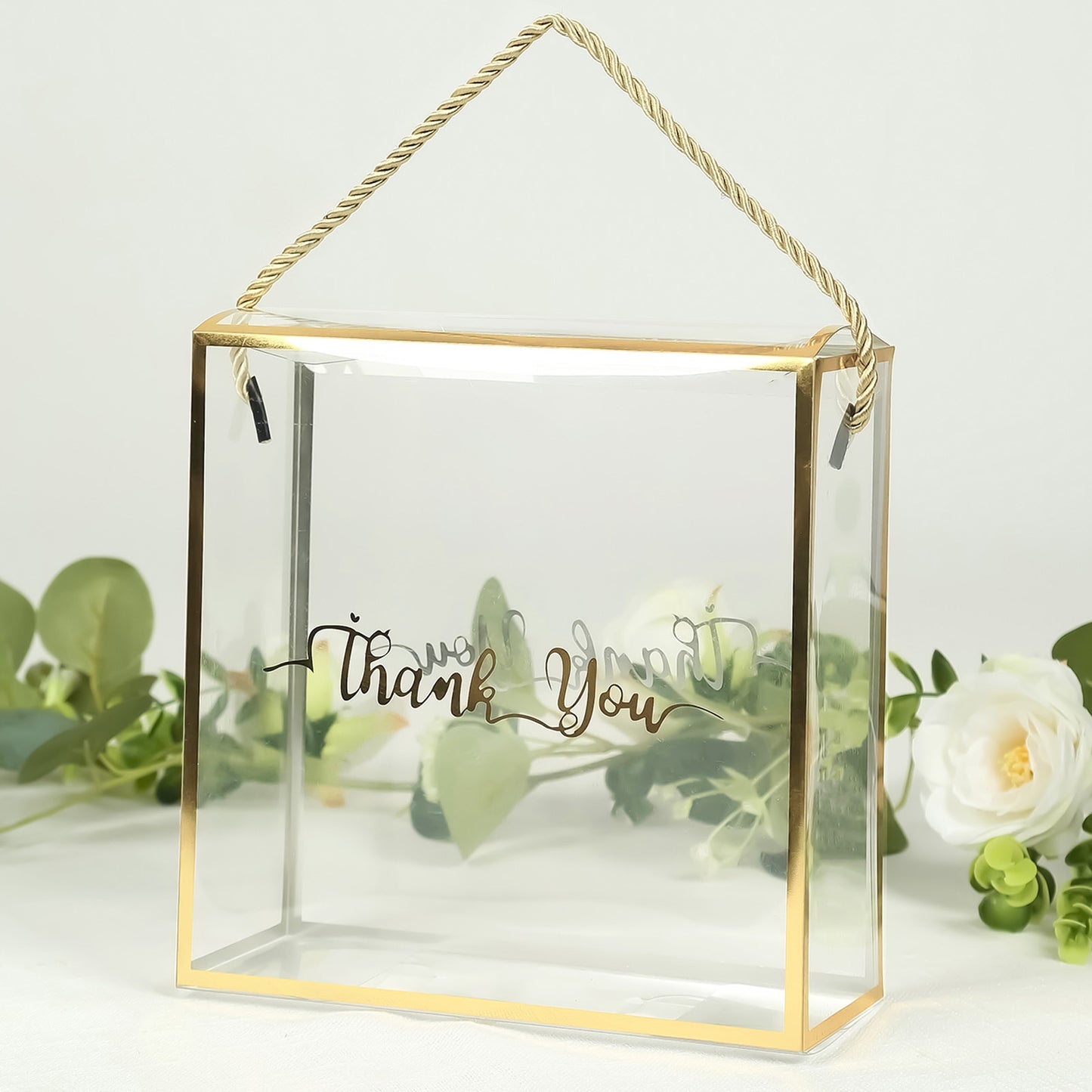 Clear gold-trimmed gift box with rope handle and "Thank You" print.