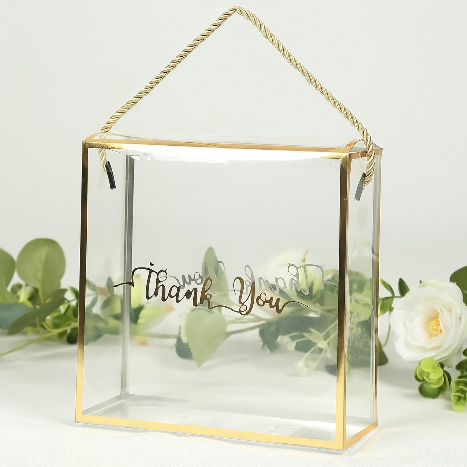 Clear gold-trimmed gift box with rope handle and "Thank You" print.