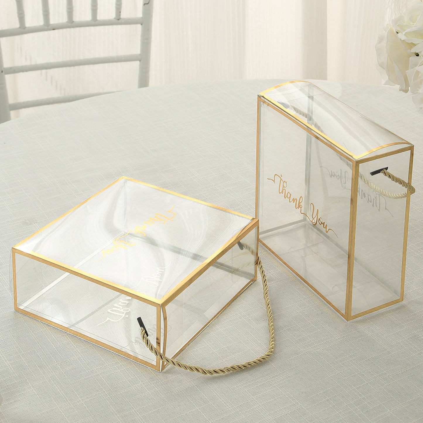 Gold trimmed clear PVC gift boxes with rope handles and "Thank You" print.