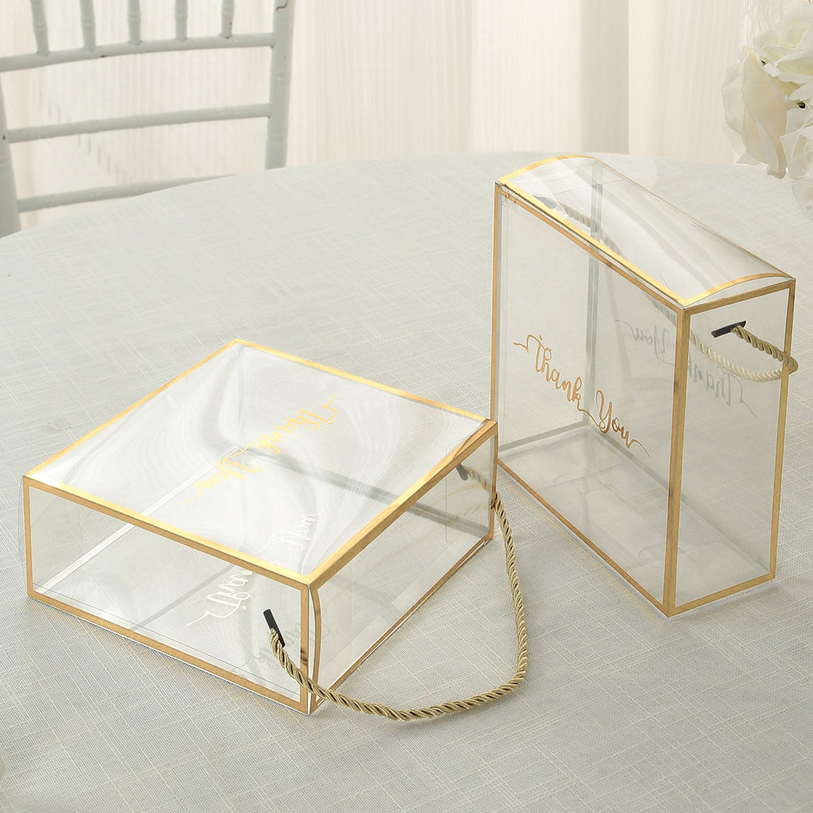 Gold trimmed clear PVC gift boxes with rope handles and "Thank You" print.