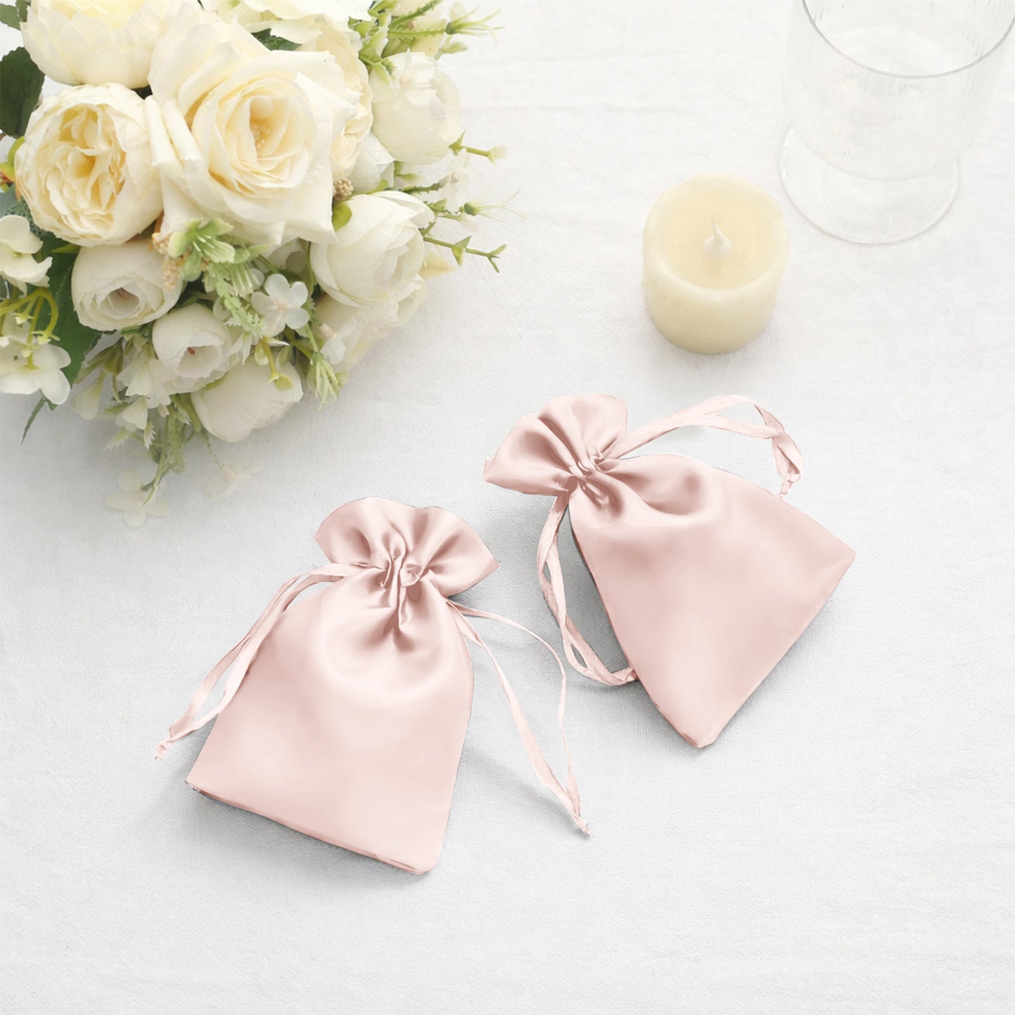 Blush satin drawstring favor bags for weddings and parties.