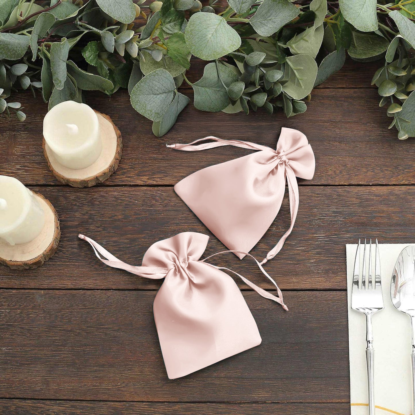 Blush satin drawstring favor bags for weddings and parties.