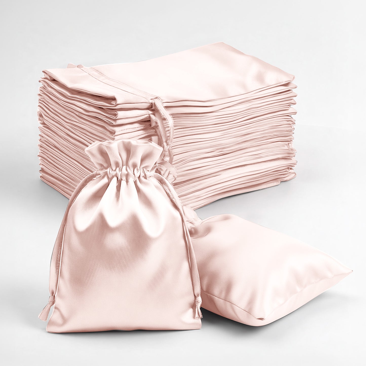 Blush satin drawstring favor gift bags for weddings and parties.