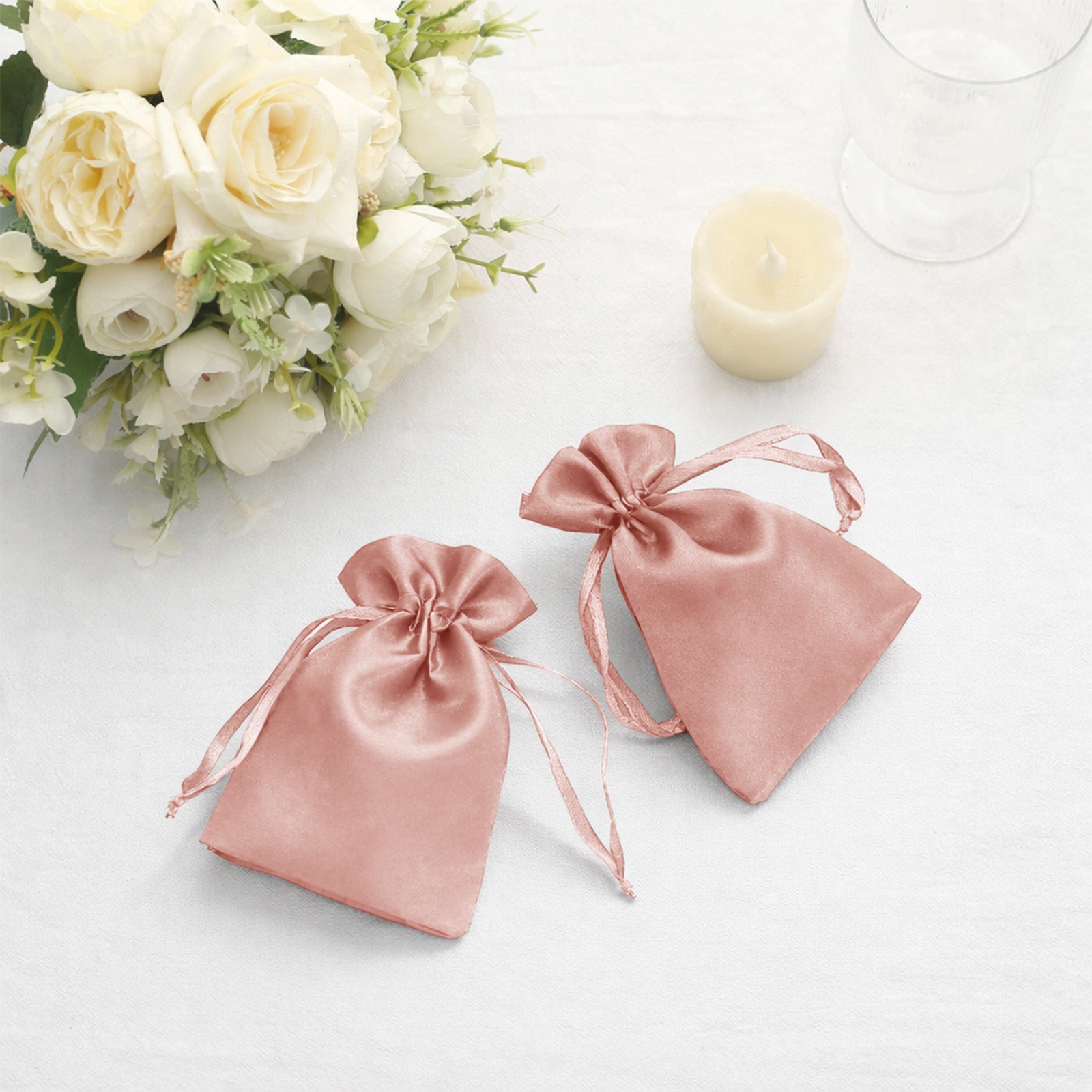Dusty rose satin drawstring favor bags for weddings and parties.
