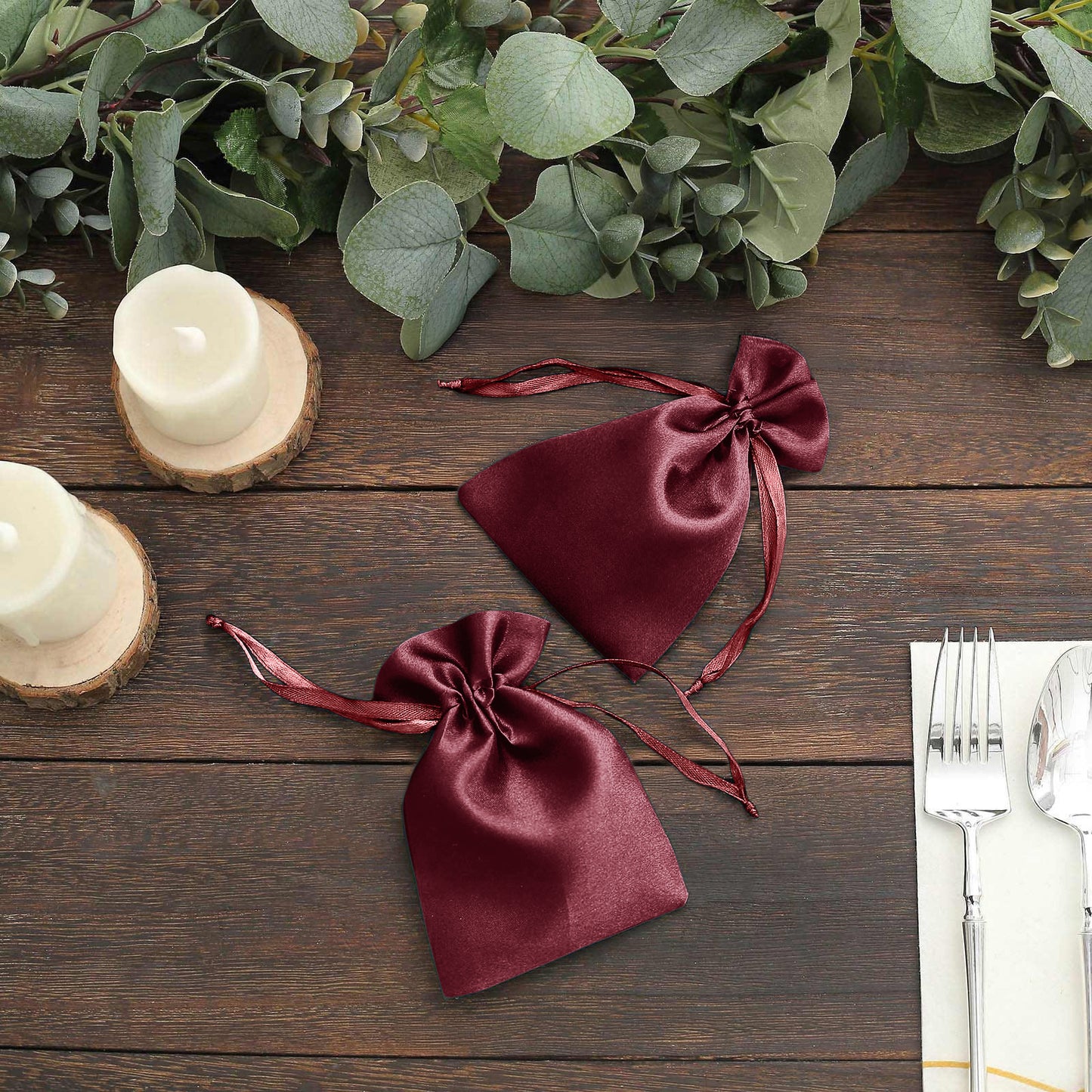 Burgundy satin drawstring favor bags for weddings and parties.