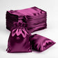 Eggplant satin drawstring favor gift bags, 3"x4", stacked with one bag in front.