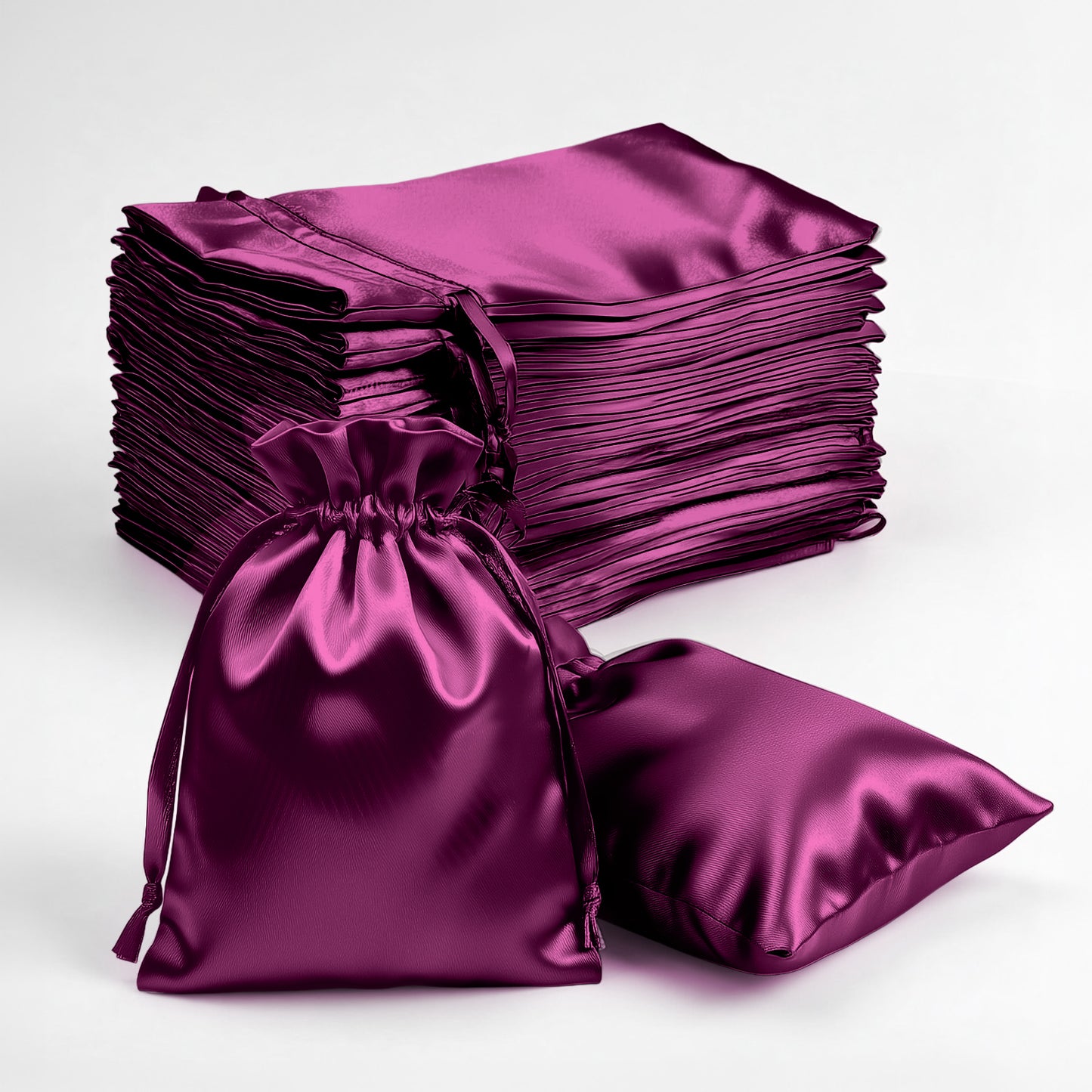 Eggplant satin drawstring favor gift bags, 3"x4", stacked with one bag in front.