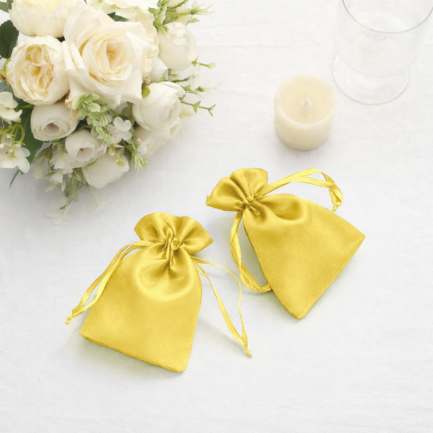 Gold satin drawstring favor gift bags for weddings and parties.