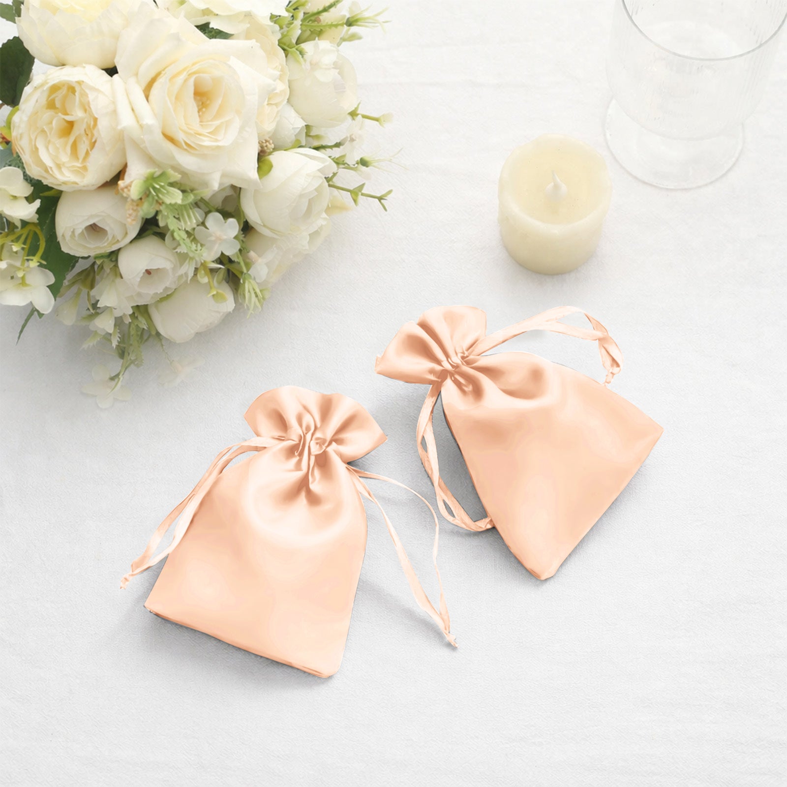 Peach satin drawstring favor bags for weddings and parties.