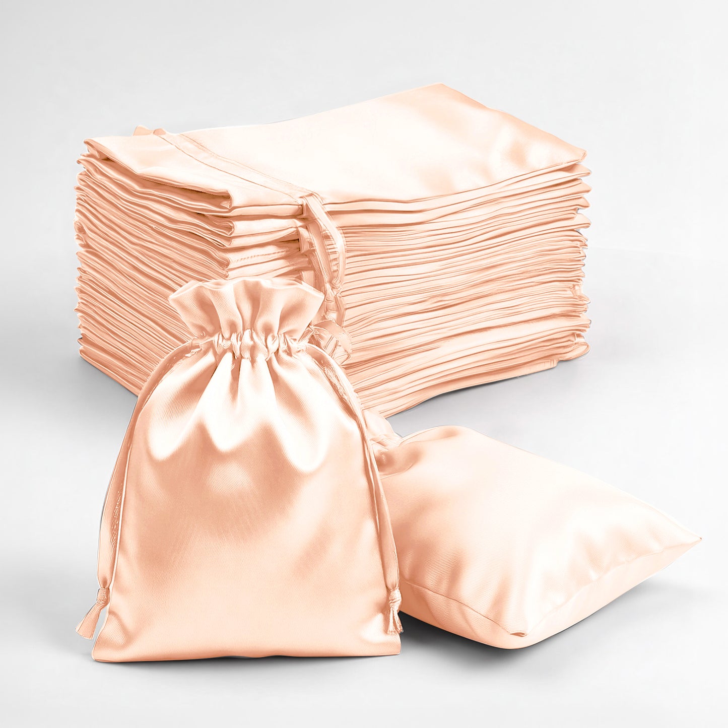 Peach satin drawstring favor gift bags for weddings and parties.