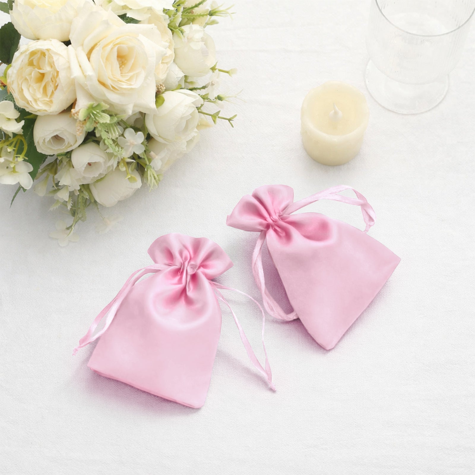Pink satin drawstring favor bags for weddings and parties.