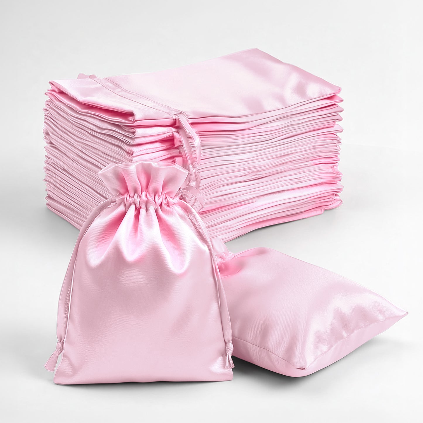 Pink satin drawstring favor gift bags, perfect for weddings and parties.